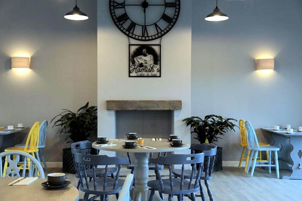 Interior of Hamish's cafe and bar with grey walls, a white column and mixed seating